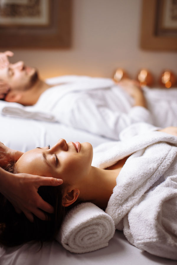 womain in a white robe receiving facial massage at nuessence spa