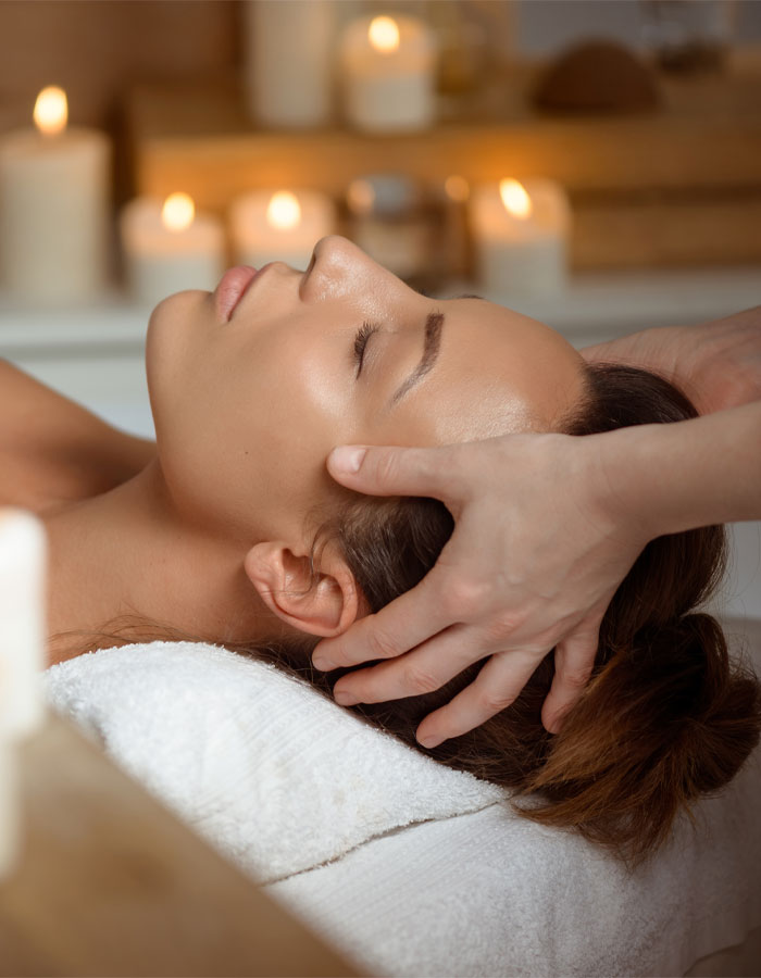 woman laying on massage table receiving head massage