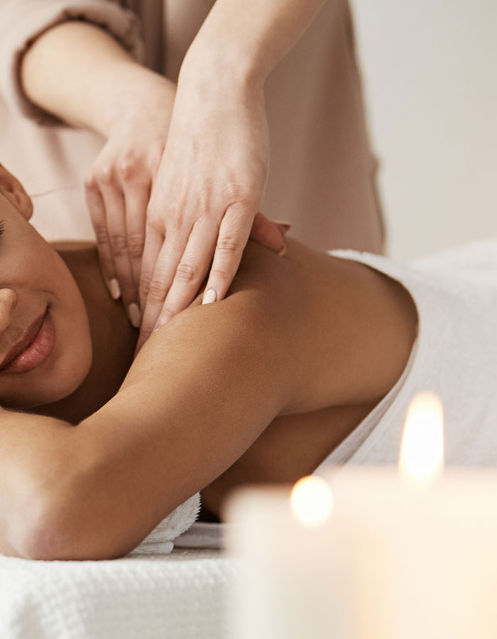 woman laying face down receiving a shoulder massage