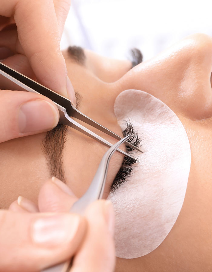 eyelash artist performing a lash lift on a woman