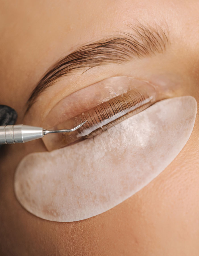 lash artist performing a lash extension for a client