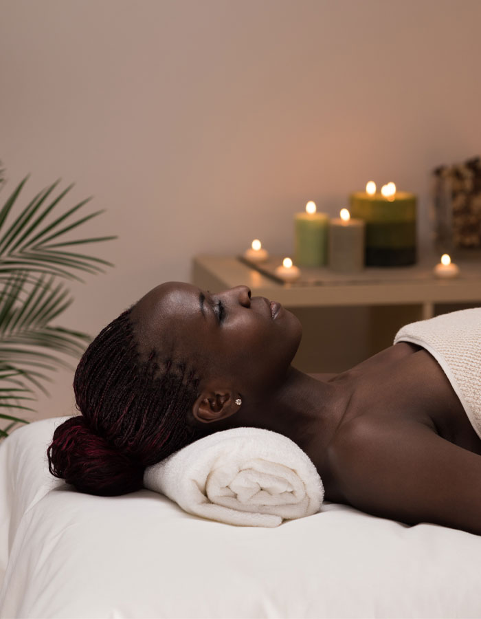 woman in a white robe resting peacefully on a massage table